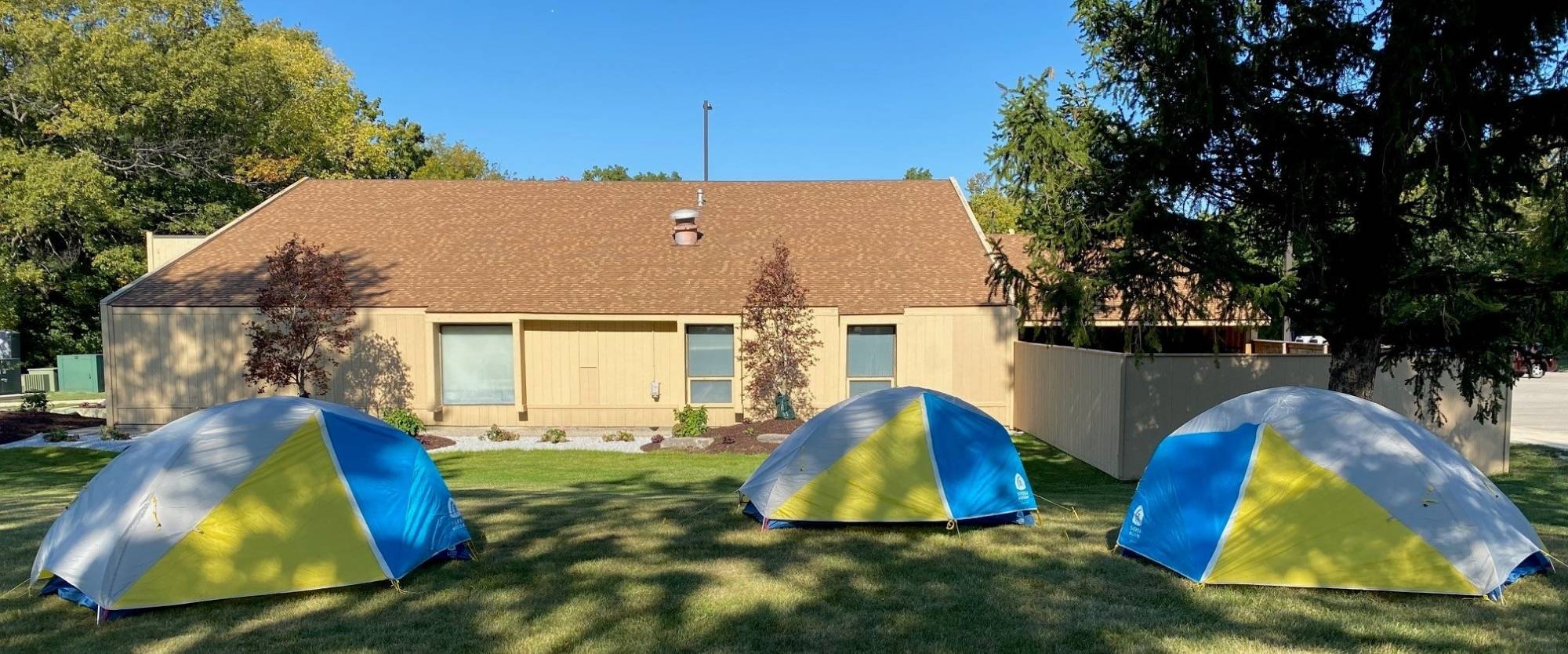 OA headquarters on a sunny day with 3 tents in the lawn